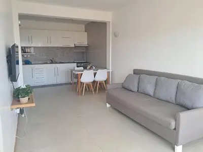 a living room with a couch and a kitchen at O Meu Aconchego em Montsú in Prainha