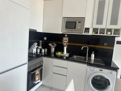 a kitchen with a washing machine and a microwave at Bestview of Palmarejo in Praia