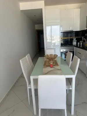 a dining room with a table and white chairs at Bestview of Palmarejo in Praia