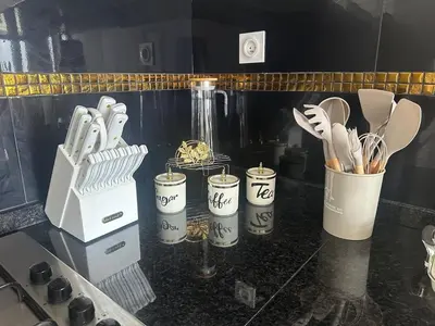 a kitchen counter with five containers of utensils at Bestview of Palmarejo in Praia