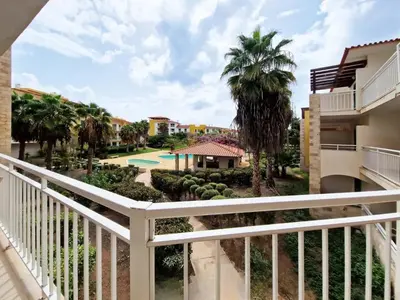 a balcony view of a resort with a pool and palm trees at 1 bedroom apartment in Vila Verde Resort in Santa Maria