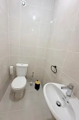 a white bathroom with a toilet and a sink at Spacious apartment in Praia Great for families in Montagarro