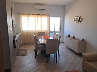 a dining room with a table and chairs and a kitchen at T1 Cá Djana in Sal Rei