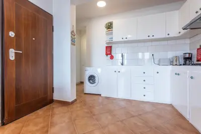 a kitchen with white cabinets and a washer and dryer at Casa do Sal - AC, Free Wi-Fi, Near Beach in Santa Maria