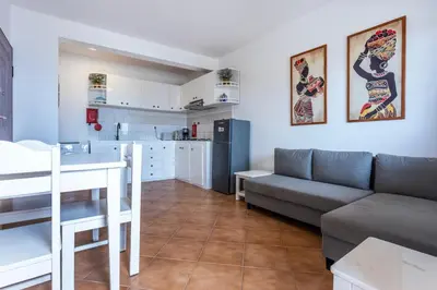 a living room and kitchen with a couch and a table at Casa do Sal - AC, Free Wi-Fi, Near Beach in Santa Maria