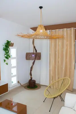 a living room with a chandelier and a table and chairs at T2 City Center in Mindelo