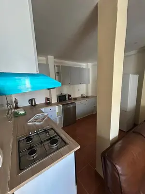 a kitchen with a stove top oven next to a couch at Home Lenda in Tarrafal