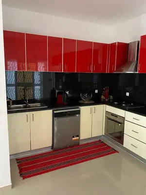 a red and white kitchen with white cabinets at Casa Melissa in Ponta do Sol