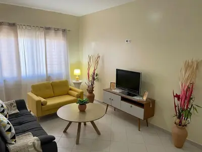 a living room with a couch and a tv at Lovely comfortable apartment in Praia in Praia