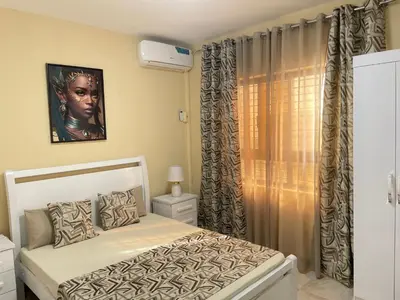 a bedroom with a white bed and a window at Hendy's cozy apt in Praia