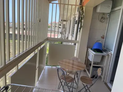 a balcony with a table and chairs and a window at Hendy's cozy apt in Praia