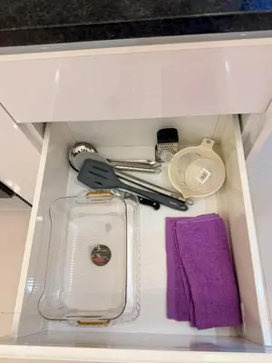 a drawer filled with utensils and a purple towel at FreLux Urban Studio in Praia