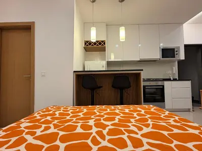 a kitchen with a large orange and white bed at FreLux Urban Studio in Praia