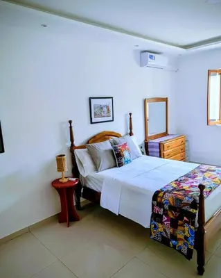 a bedroom with a bed and a dresser and a bed sidx sidx sidx sidx at Nos Kaza in Cidade Velha