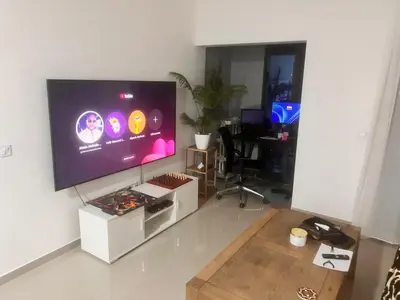 a living room with a large flat screen tv on a wall at Bright Modern Apart Mountain View, 5 Min to Beach in Praia