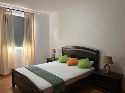 a bedroom with a bed with green and orange pillows at Casa Fernandes in Praia
