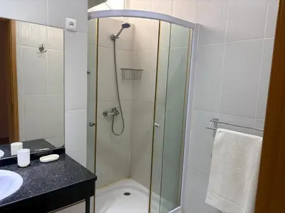 a bathroom with a shower with a glass door at Casa Fernandes in Praia