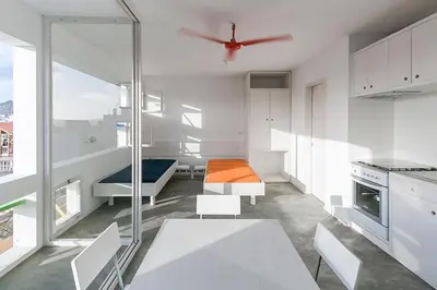 a kitchen with white cabinets and a ceiling fan at Central studio Nomad friendly 1B in Mindelo