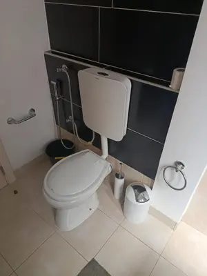 a bathroom with a white toilet and a trash can at Pires's House in Mindelo