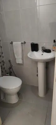 a white bathroom with a toilet and a sink at Pires's House in Mindelo