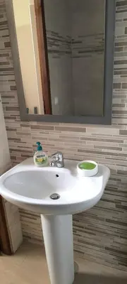 a white sink in a bathroom with a mirror at Pires's House in Mindelo
