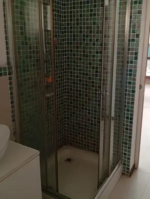 a bathroom with a shower with green tiles at Sol Lazareto Mindelo in Prainha
