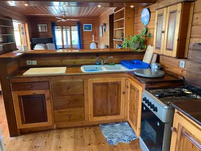 a kitchen with wooden cabinets and a sink and a stove at Casa TROPIKAL Maio Ponta Preta in Vila do Maio