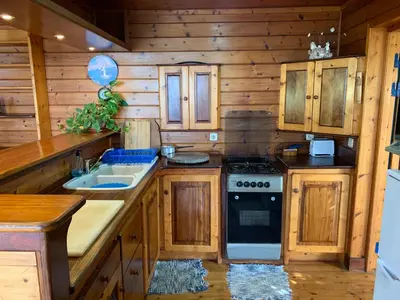 a kitchen with wooden cabinets and a stove at Casa TROPIKAL Maio Ponta Preta in Vila do Maio