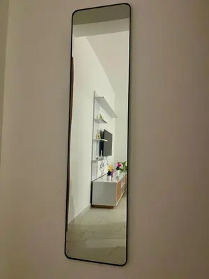 a mirror hanging on a wall with a bathroom at Encanto do Mar in Santa Maria