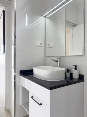 a white bathroom with a sink and a mirror at 2 bdr aprt, stunning view, rooftop pool - LCGR in Praia