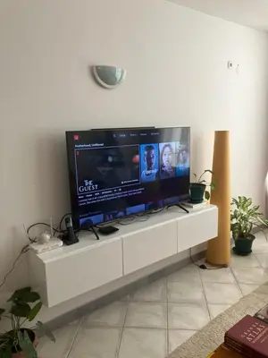 a large flat screen tv sitting on a white entertainment center at AkyaSpot in Praia