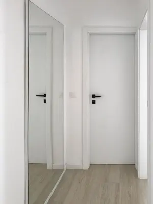 two white doors in a room with a mirror at Spacious 2 bdr aprt, rooftop pool - LCGR in Praia