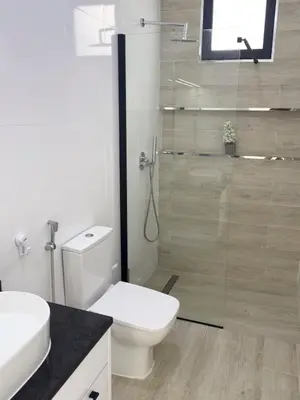 a bathroom with a toilet and a glass shower at Spacious 2 bdr aprt, rooftop pool - LCGR in Praia