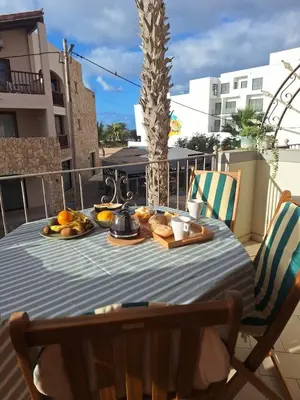 a table on a balcony with fruit on it at Apart T2 em frente à Praia - Centro de Santa Maria in Santa Maria