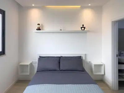 a bedroom with a bed with two shelves on the wall at Cozy 2 bdr aprt, rooftop pool - LCGR in Praia
