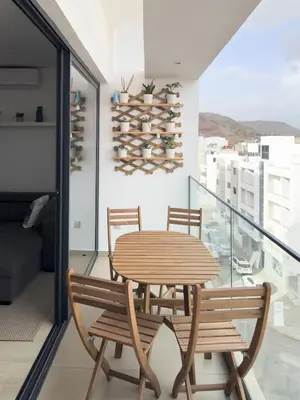 a wooden table and chairs on a balcony at Cozy 2 bdr aprt, rooftop pool - LCGR in Praia