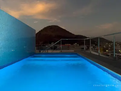a swimming pool on the roof of a building at Cozy 2 bdr aprt, rooftop pool - LCGR in Praia