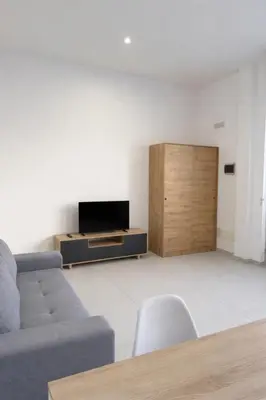 a living room with a couch and a flat screen tv at AQUÁRIO Hotel in Sal Rei