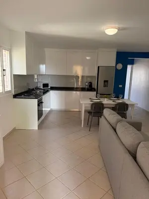 a living room with a couch and a kitchen at Estrela do Sul Santa Maria by RPG Group in Santa Maria