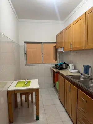 a small kitchen with a table and a sink at Legacy cv in Praia