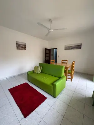 a living room with a green couch and a table at Legacy cv in Praia