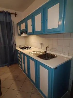 a kitchen with blue cabinets and a sink at Holiday Properties Ca' Meli - Wi-fi in Santa Maria