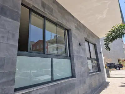 a group of windows on the side of a building at CV Edifício Vitória, RC Centro - PALMAREJO BAIXO in Praia