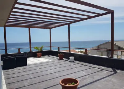 a wooden deck with a view of the ocean at C Varela C - Casa Branca in Praia