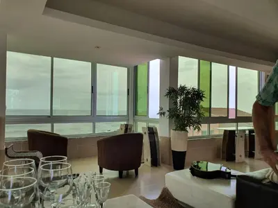 a dining room with a table and chairs and windows at C Varela C - Casa Branca in Praia