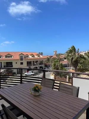 a wooden table on the balcony of a house at Central Santa Maria Sea view 2 Bedroomed Apartment in Santa Maria