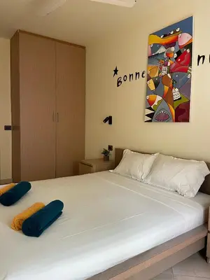 a bedroom with a white bed with blue pillows on it at Central Santa Maria Sea view 2 Bedroomed Apartment in Santa Maria