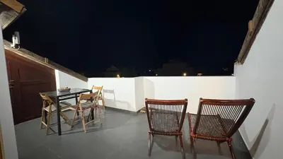 a table and chairs on a balcony at night at Casa Rosa Sal in Santa Maria