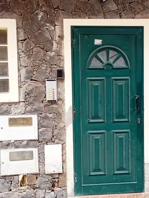 a green door on the side of a stone building at Rosa dei venti 4 in Santa Maria