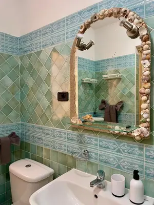 a bathroom with a toilet and a sink and a mirror at Rosa dei venti 4 in Santa Maria